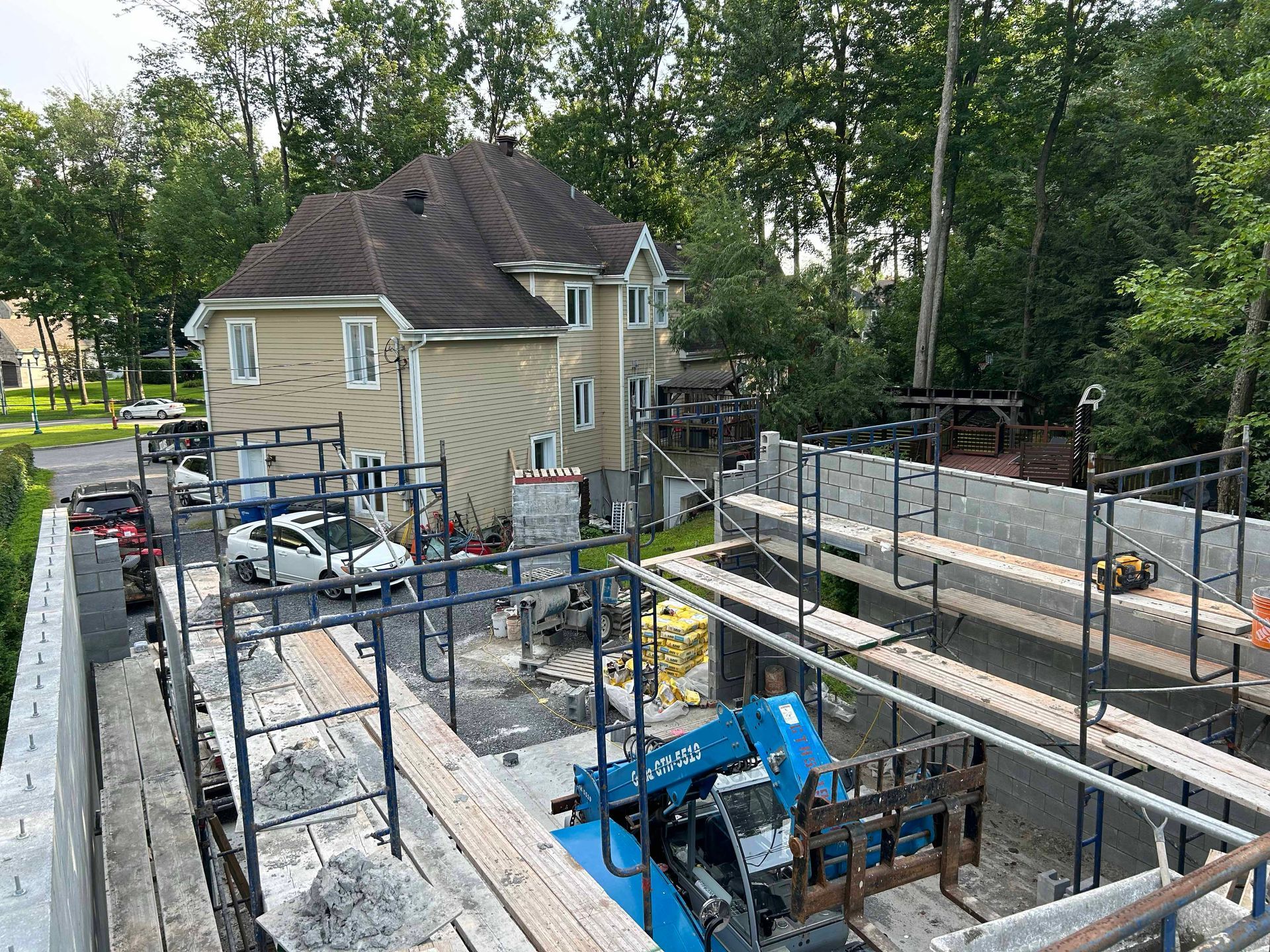 Une grande maison est en construction avec des échafaudages autour.