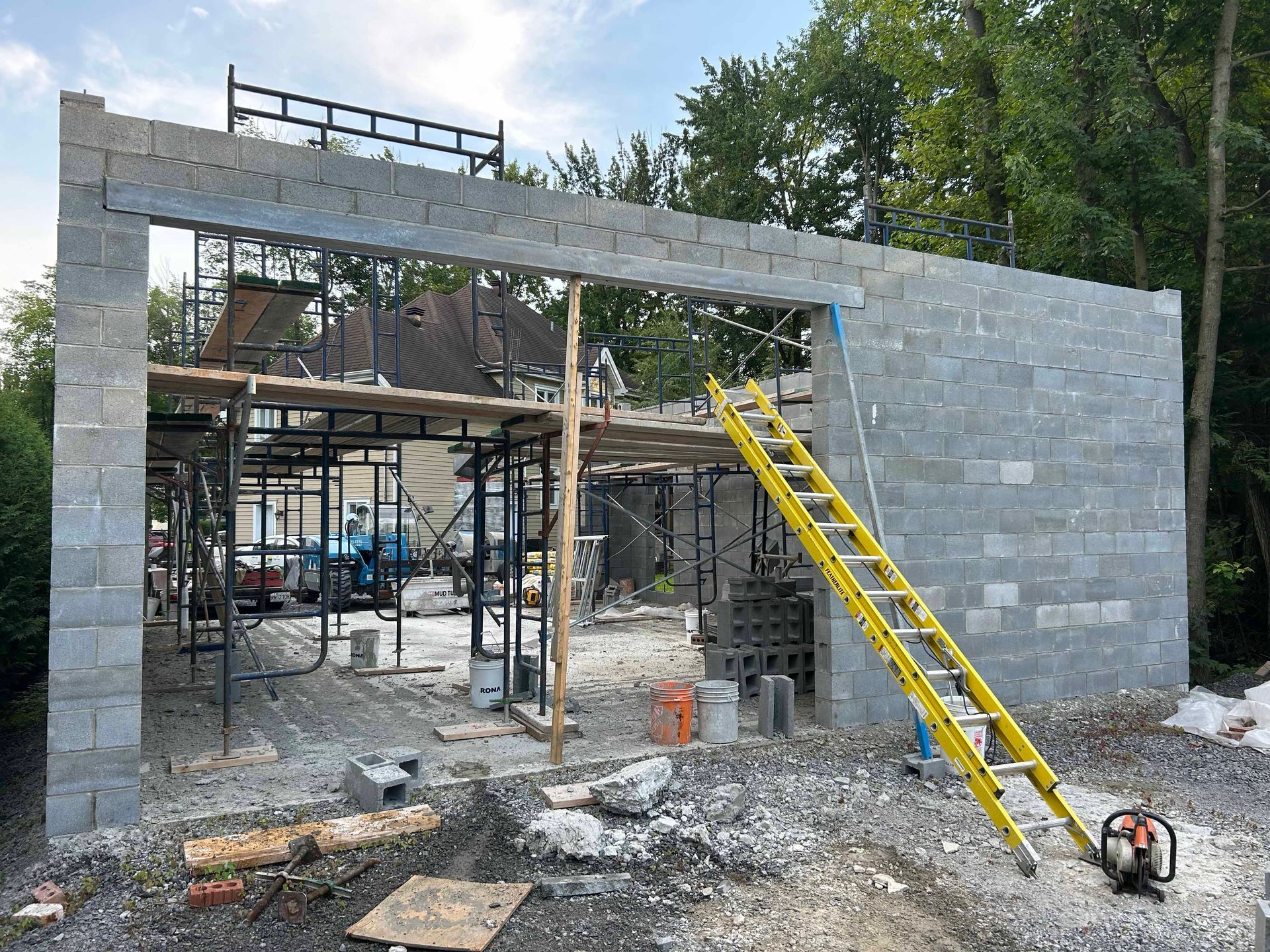Une échelle jaune se trouve sur le côté d'un bâtiment en construction.