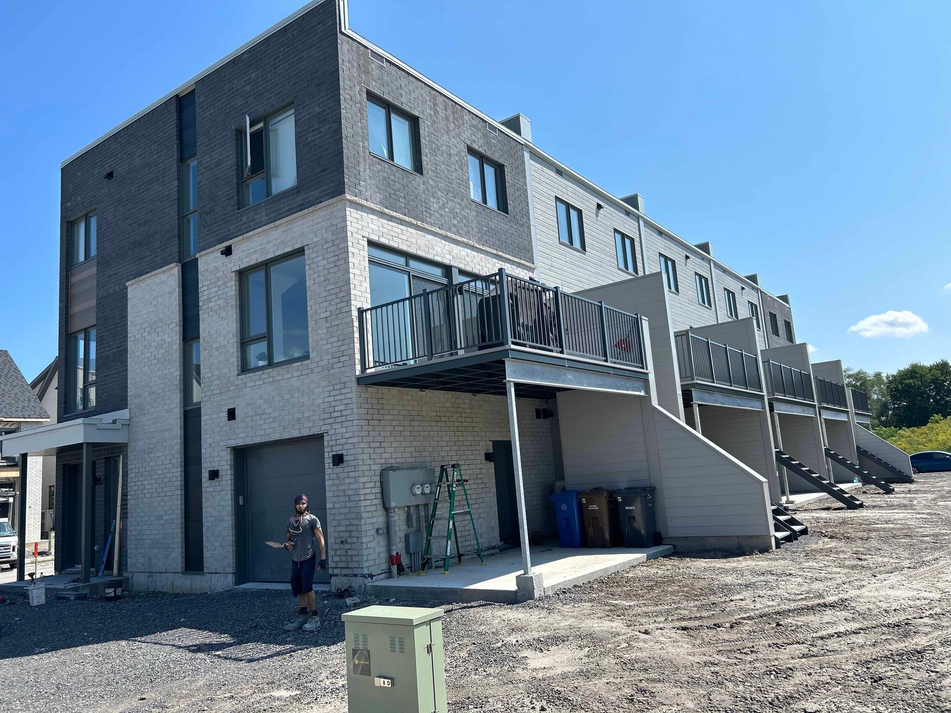 Un homme se tient devant un bâtiment en construction.