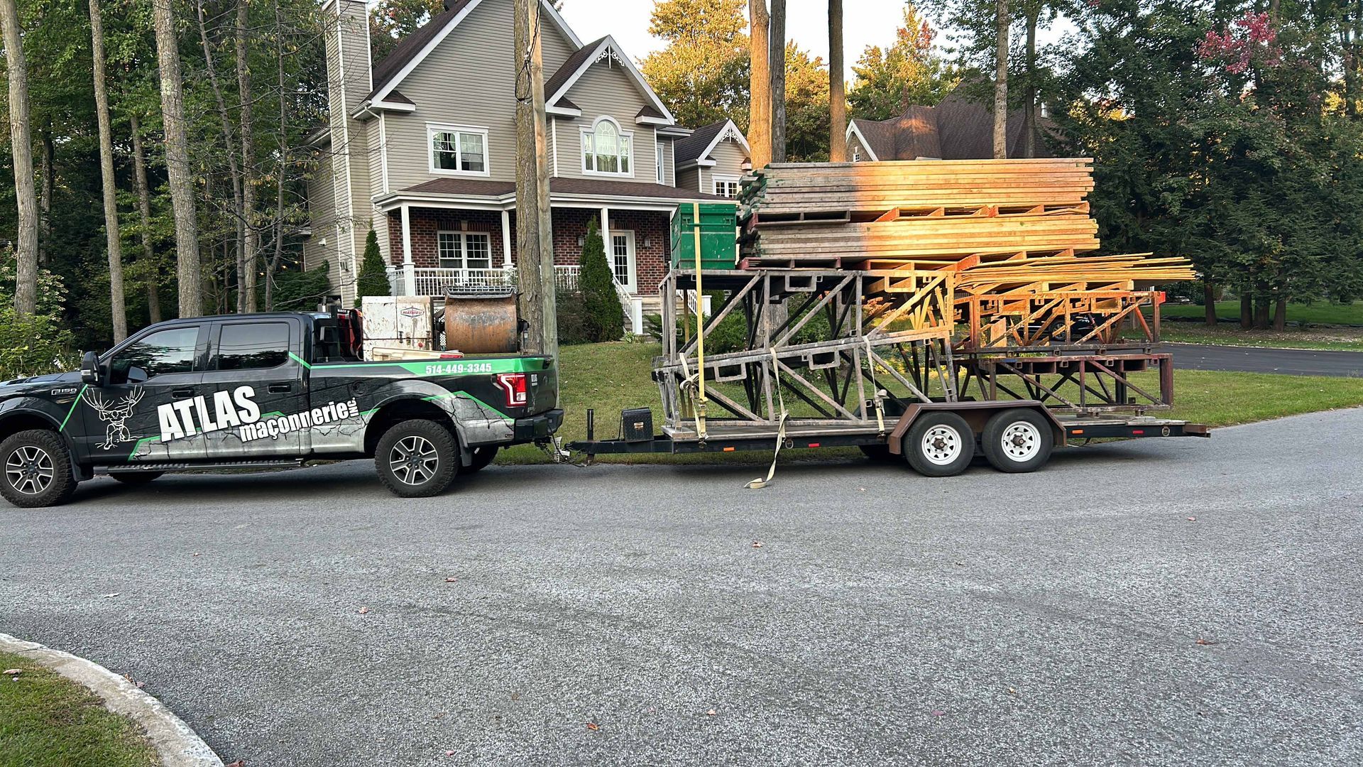 Un camion tire une remorque pleine de bois.