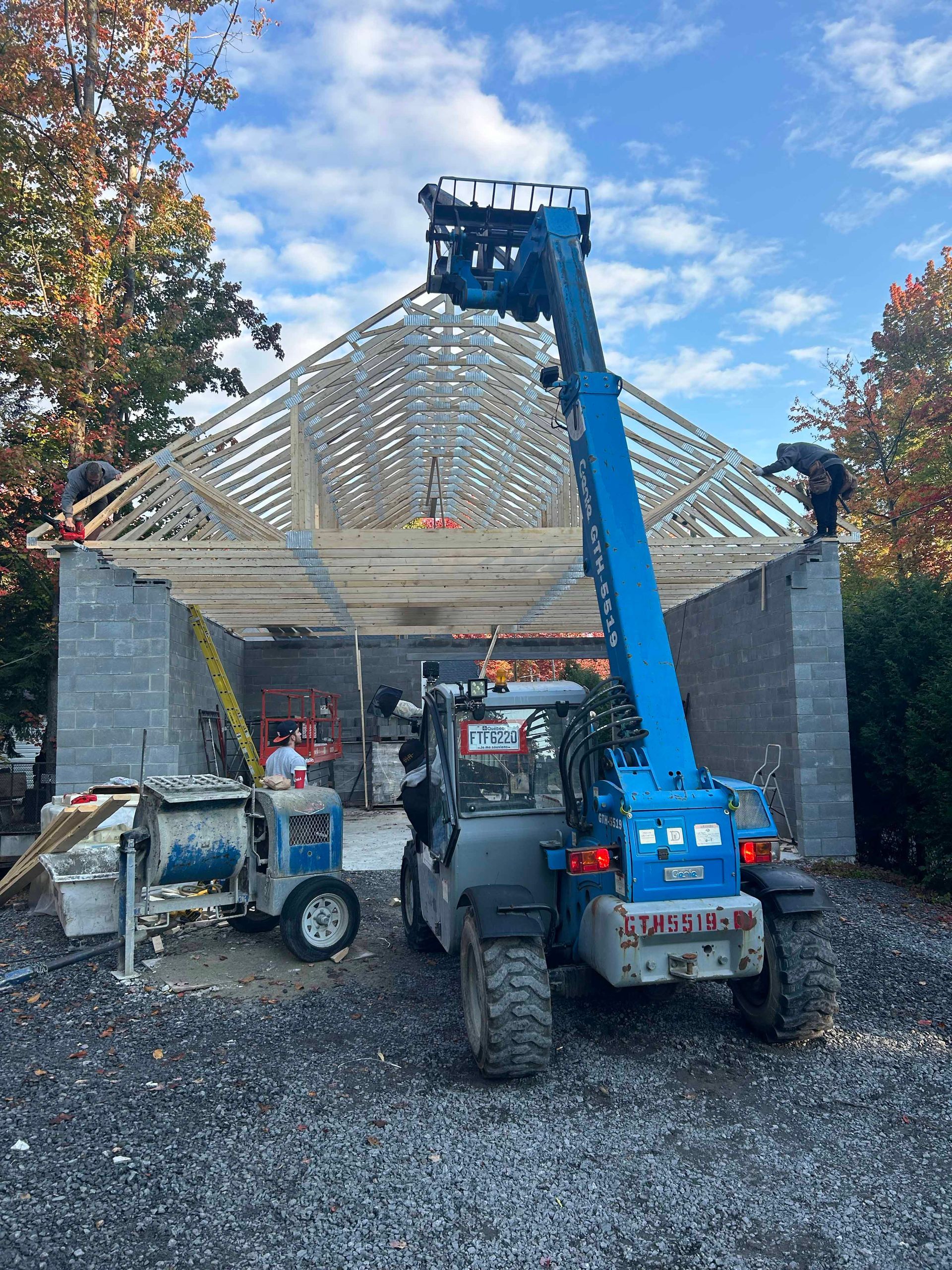 Une grue bleue est utilisée pour construire un garage.