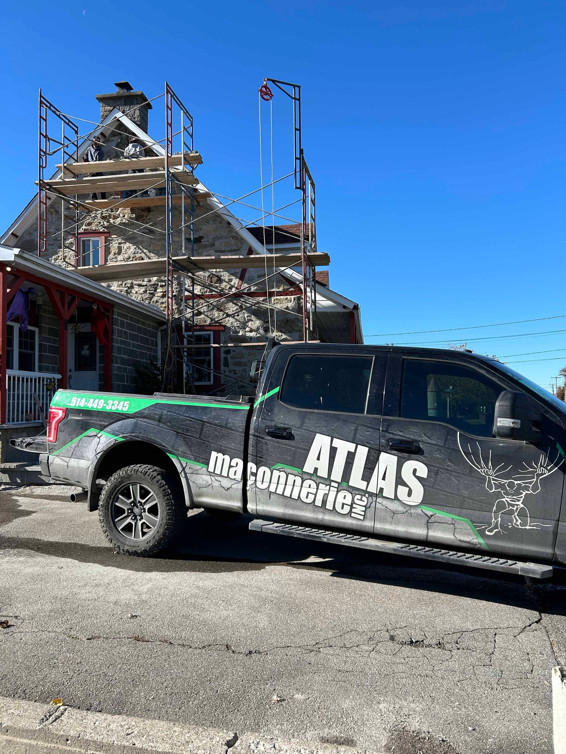 Un camion atlas est garé devant un bâtiment en construction.