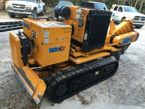 A stump grinder is grinding a tree stump in a yard.