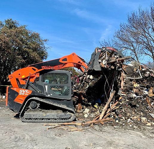 A bulldozer is cleaning up a pile of rubble.