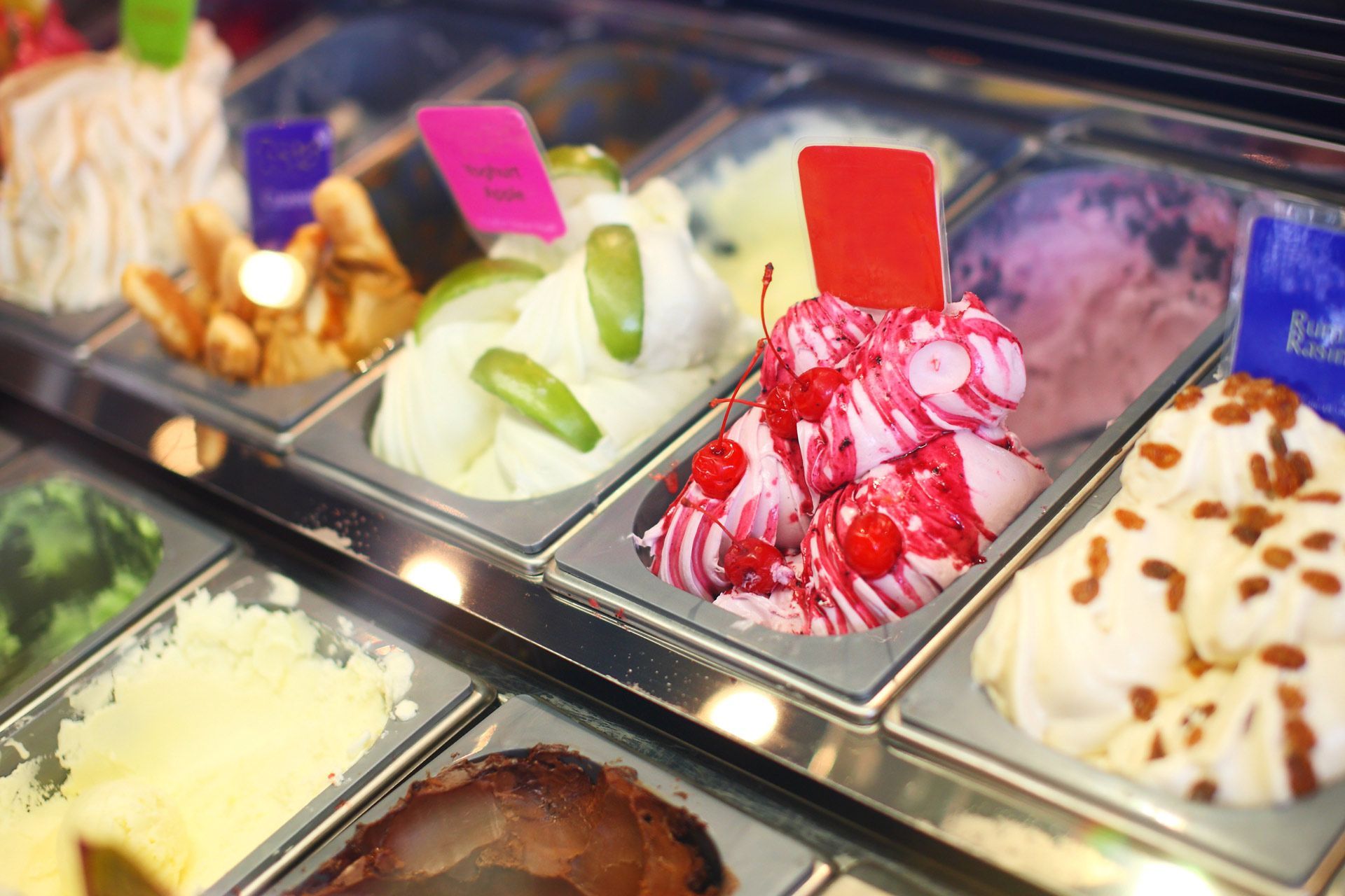Ice cream display case with various colorful gelato flavors.