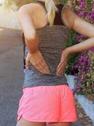 Woman Suffering Body Pain - Lower Back in Laguna Beach, CA