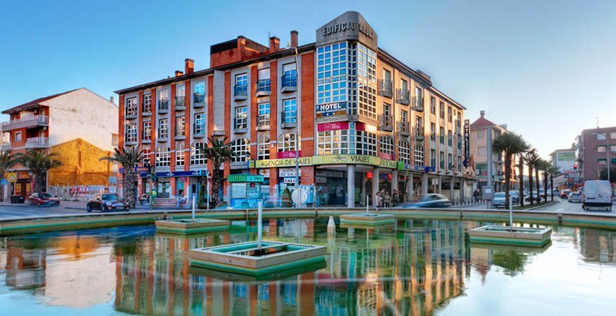 Un edificio grande con un estanque delante.