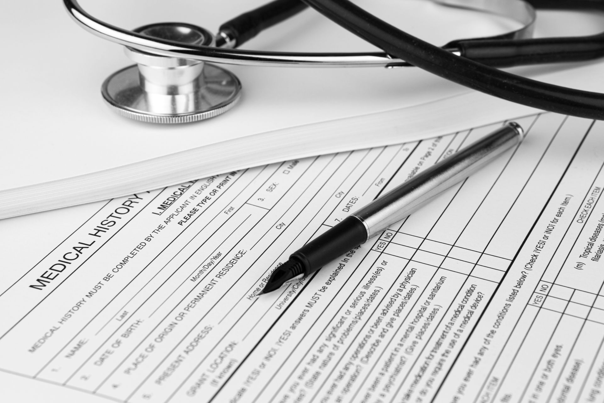 A stethoscope sits on top of a medical report
