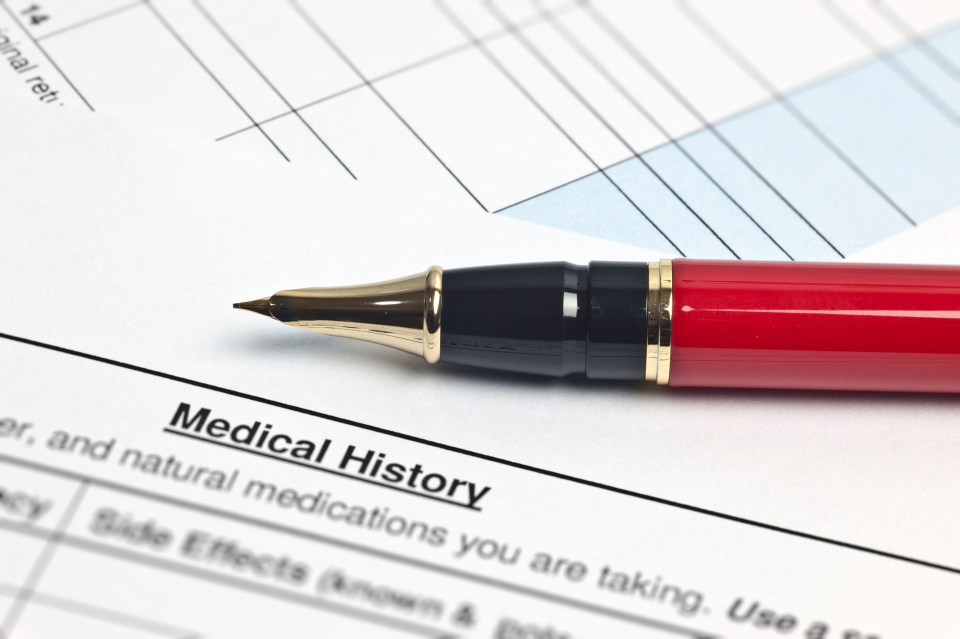 A red pen is sitting on top of a medical history form