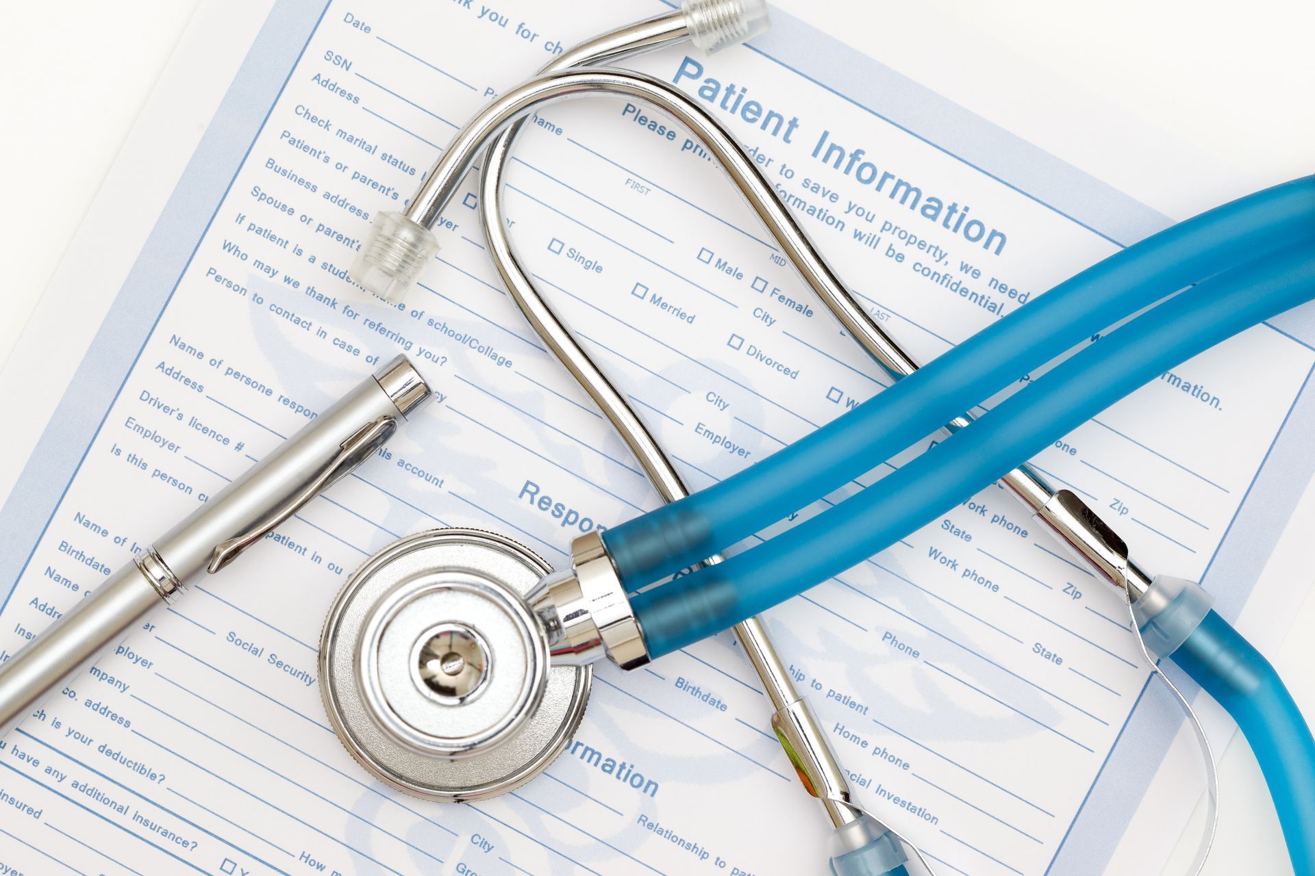 A stethoscope is laying on top of a patient information form