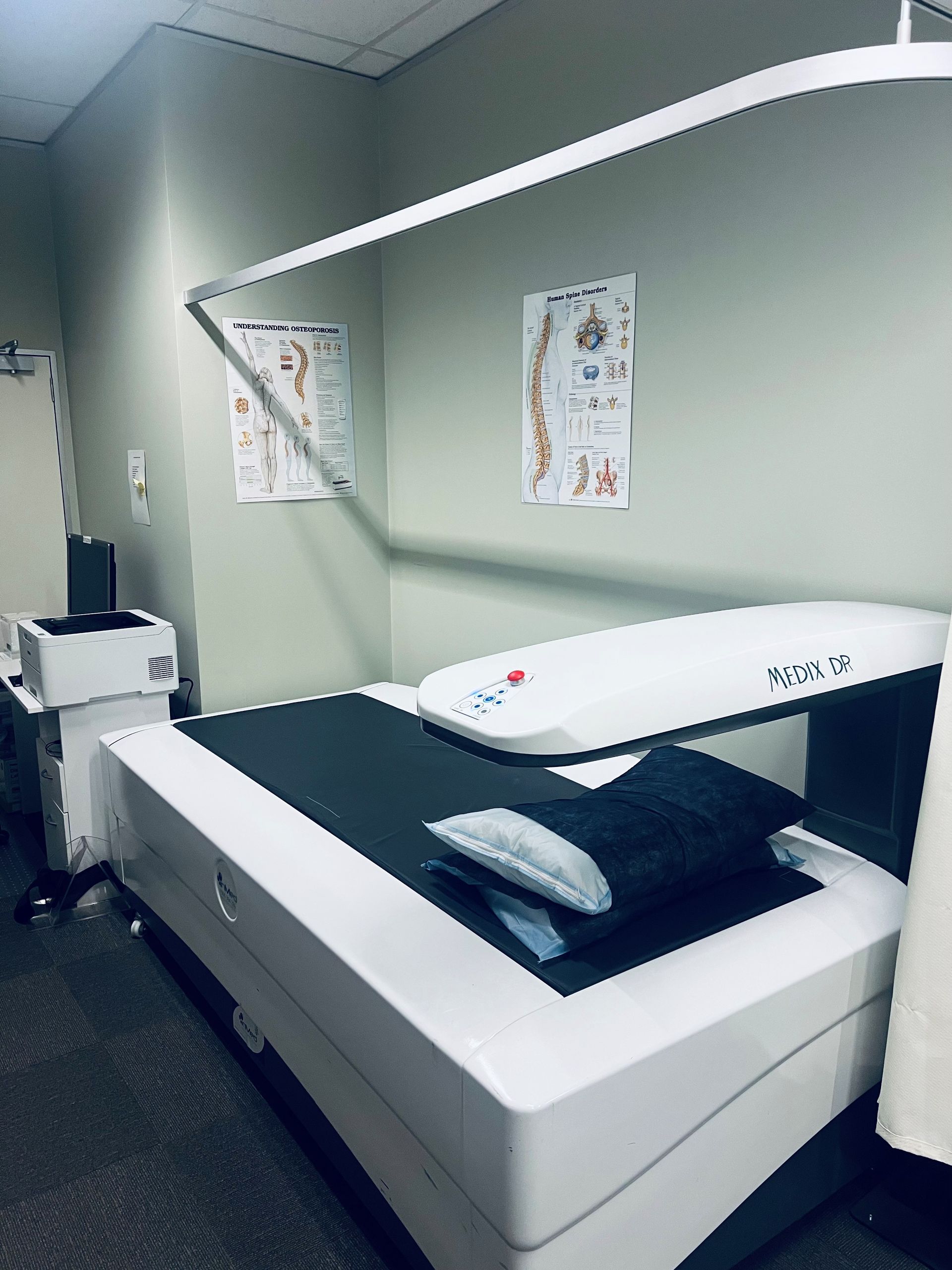 A doctor 's office with a bed and a computer.