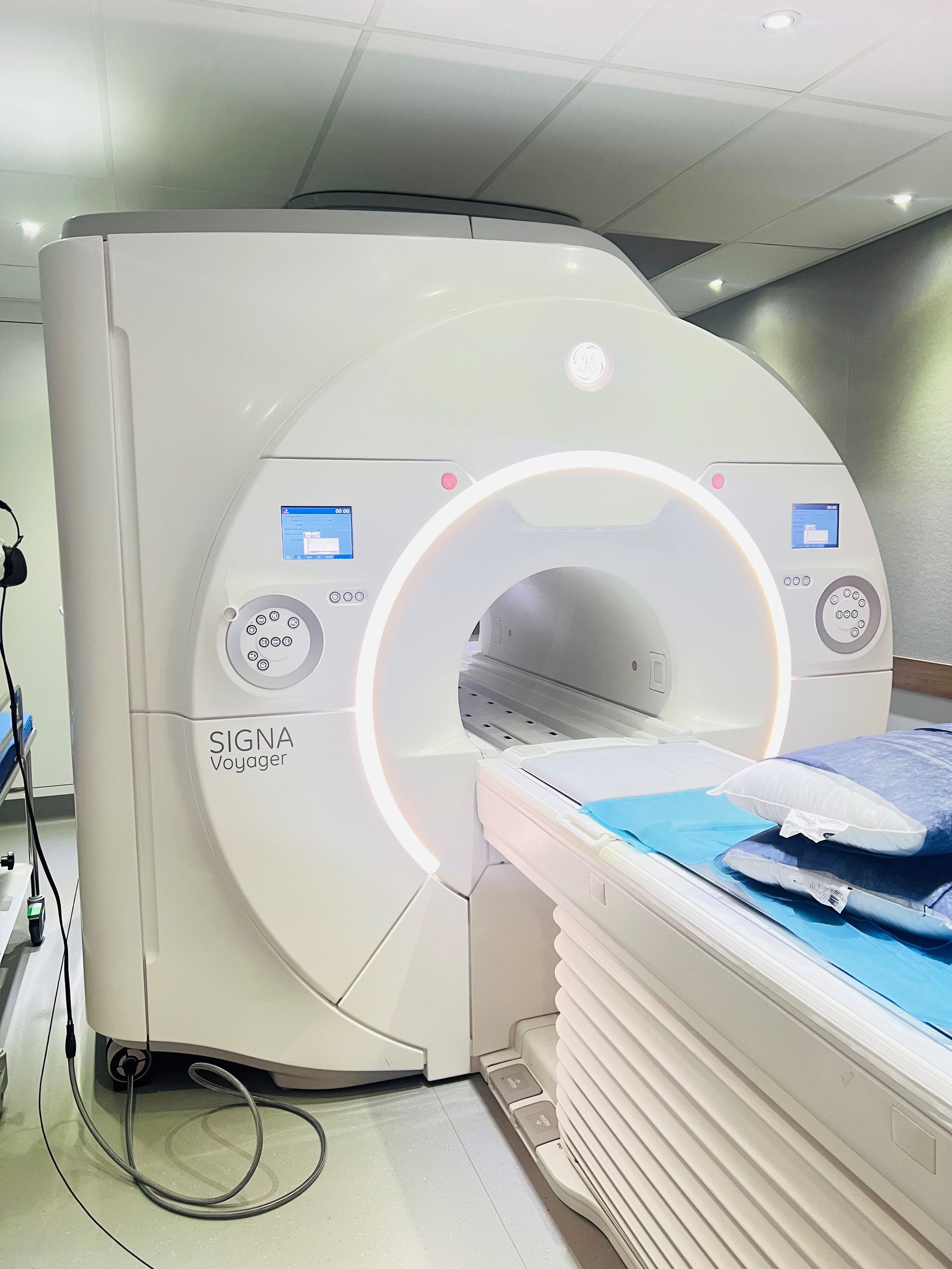 A person wearing blue gloves is pointing at an x-ray of a brain.