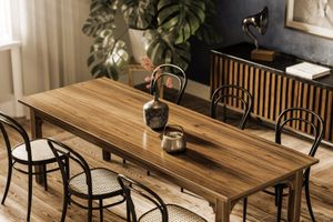 Dining room with wooden table, chairs, and decorative items.