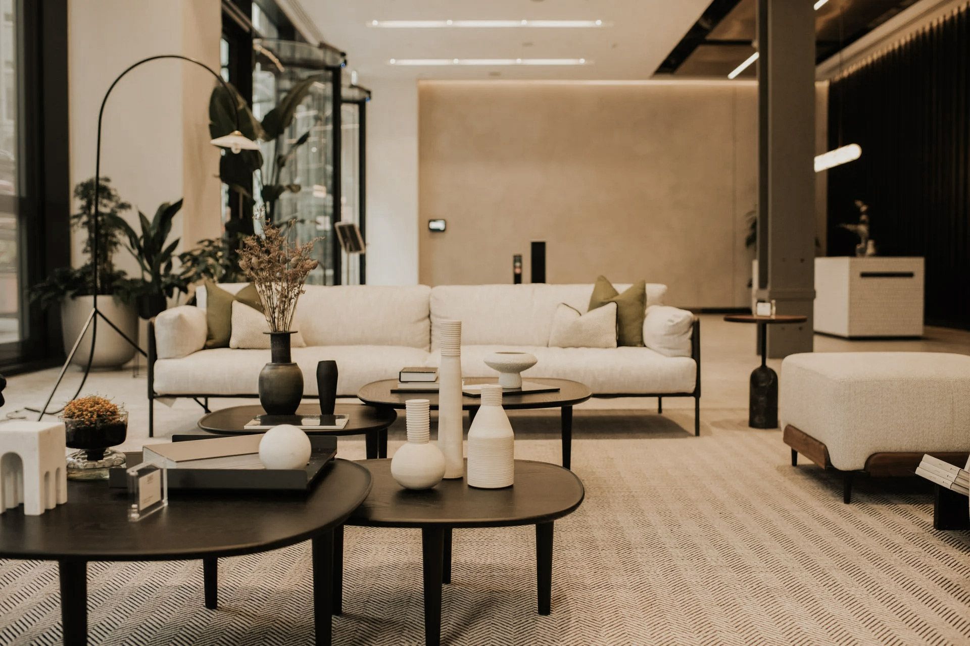 Living room with modern furniture, neutral colors, and decorative items.