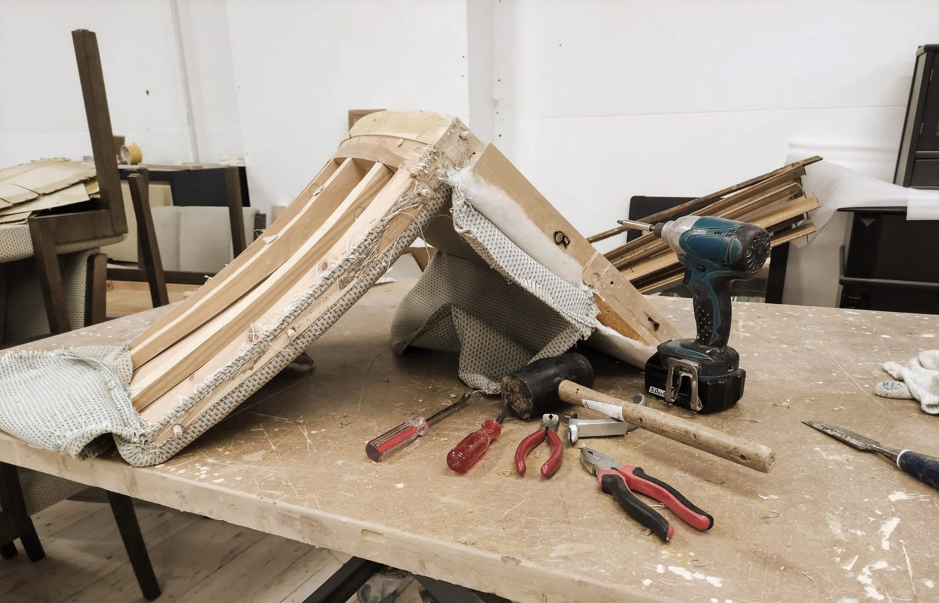 Workbench with furniture frame, tools, and sawdust.