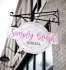 Sign for Simply Blush Bridal with cursive pink text, hanging from a black bracket on a brick building.