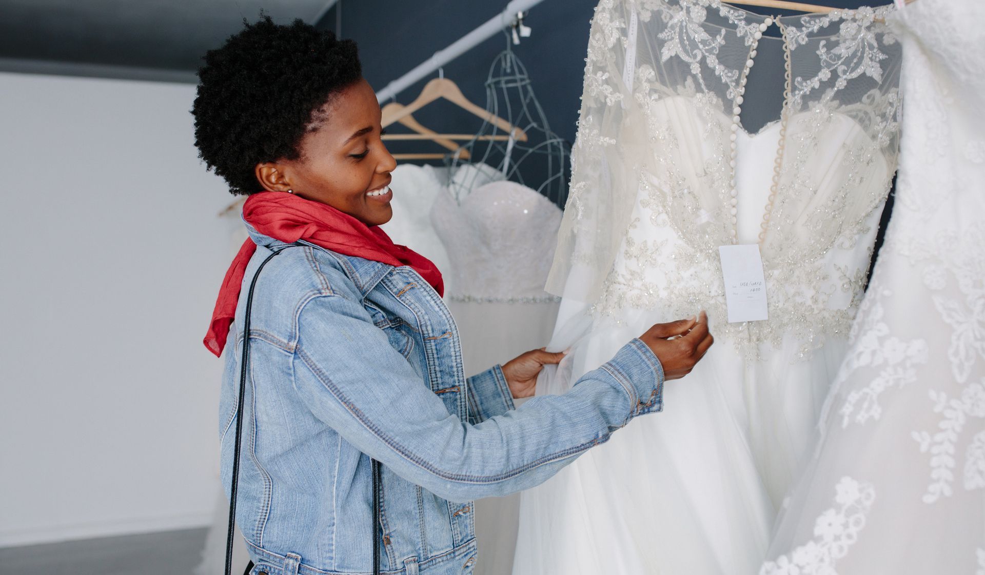 A woman is looking at a wedding dress in a store.