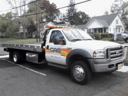 A white tow truck with the word cas on the side