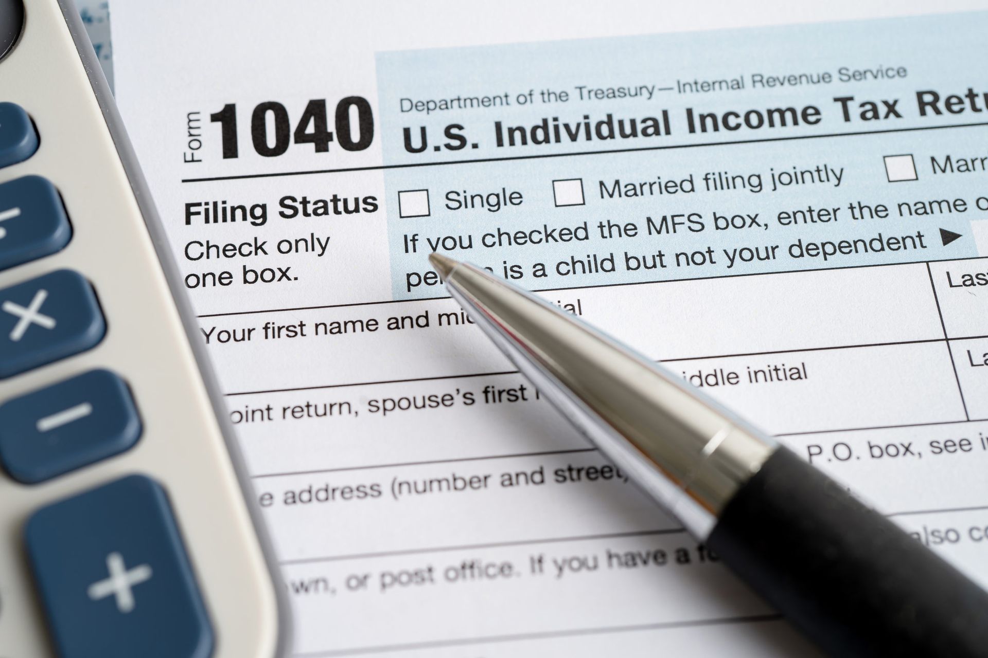 A pen is on top of a 1040 u.s. individual income tax form