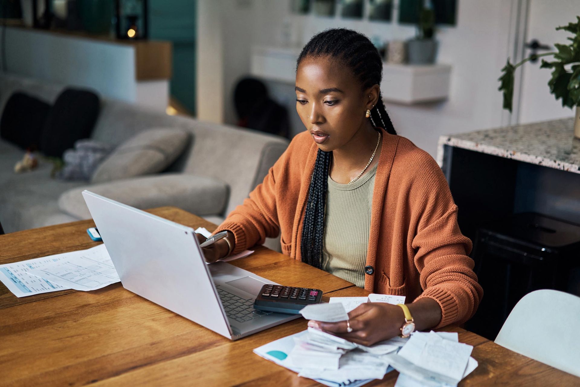 A woman is sitting at a table using a laptop computer.