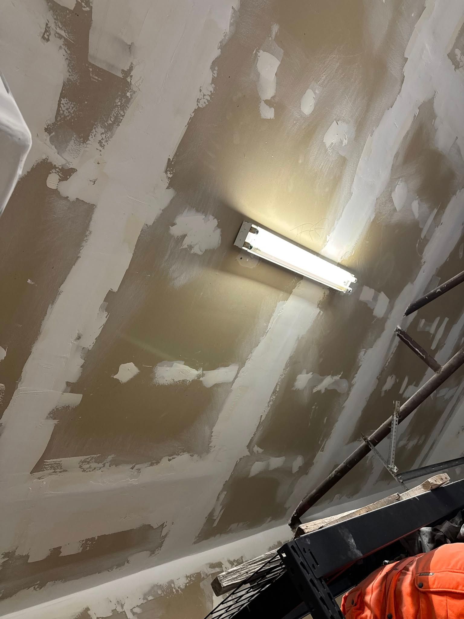 Garage ceiling with exposed drywall seams and a fluorescent light fixture.