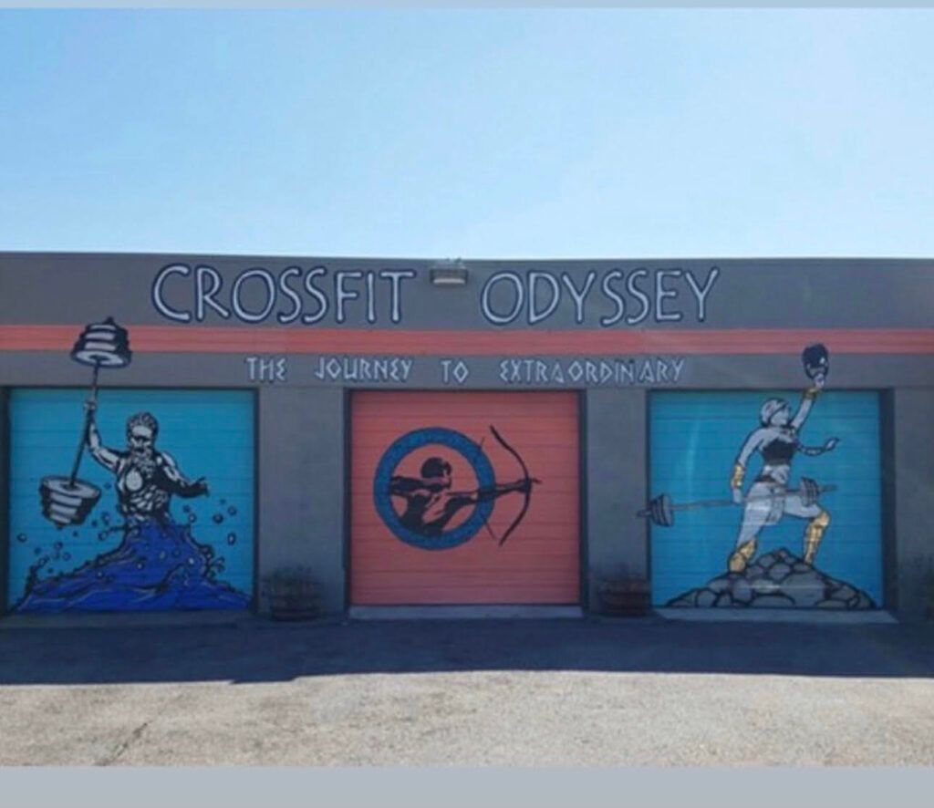 A crossfit odyssey gym with a mural on the garage doors