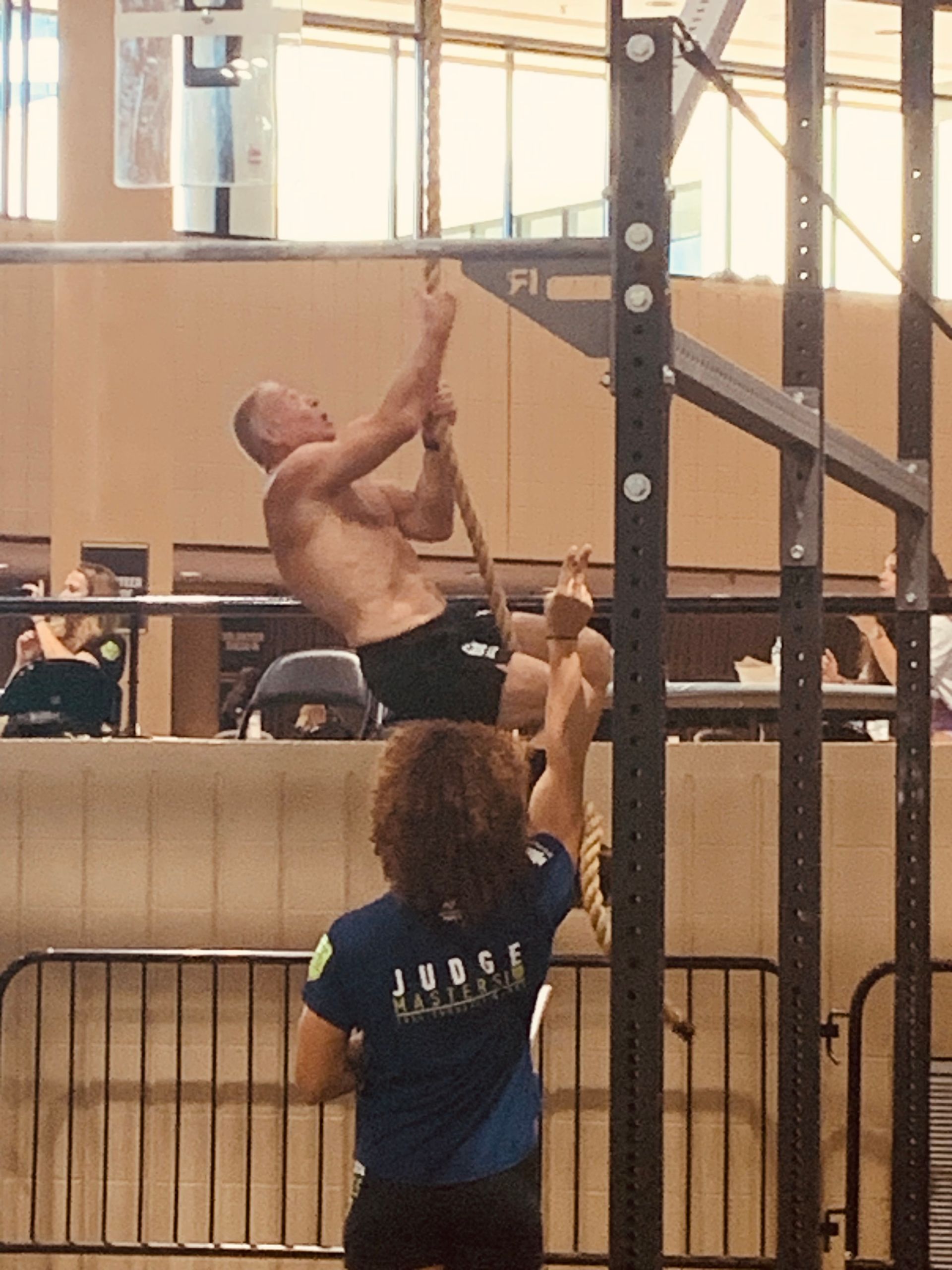 A man is climbing a rope while a woman watches