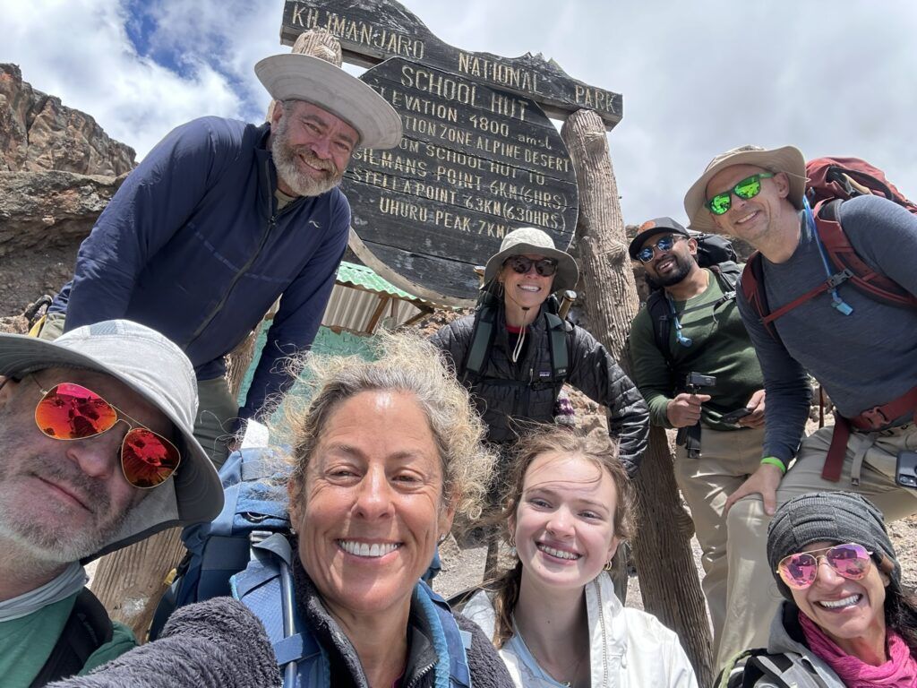 A group of people are posing for a picture on top of a mountain.