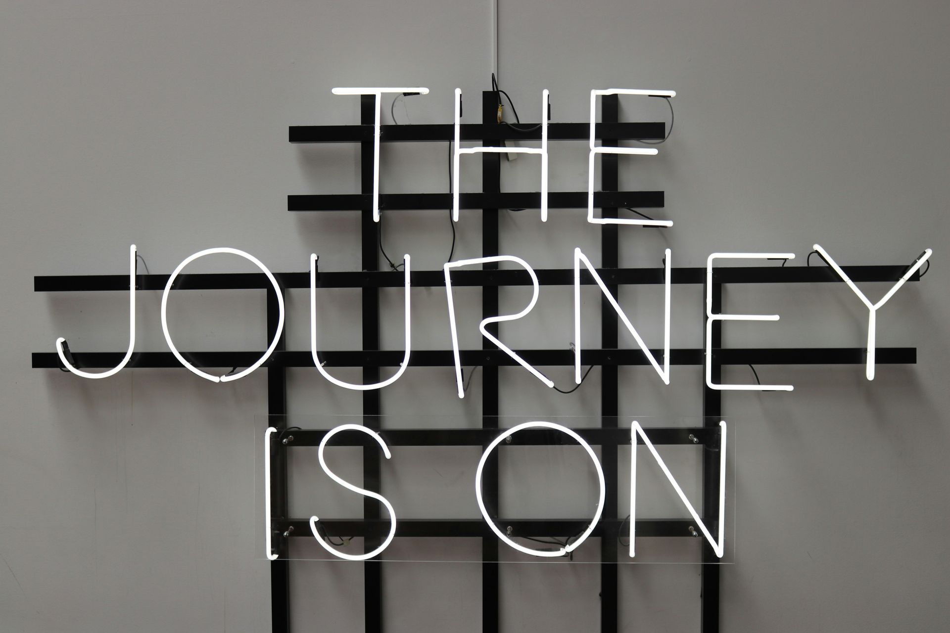 A neon sign that says the journey is on