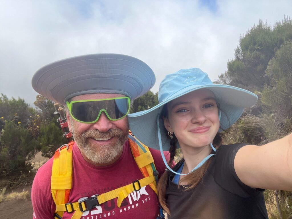 A man and a woman wearing hats and sunglasses are taking a selfie.
