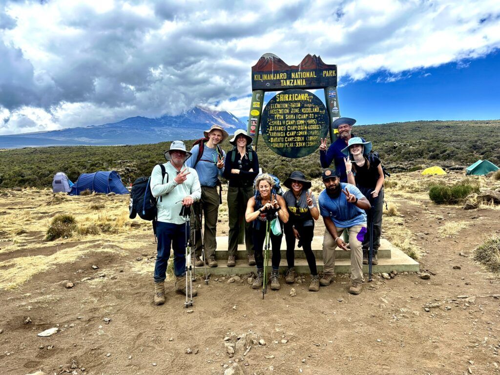 A group of people are posing for a picture in front of a sign.