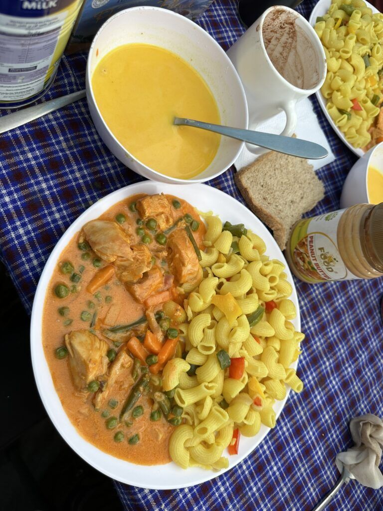 A plate of pasta and a bowl of soup on a table.