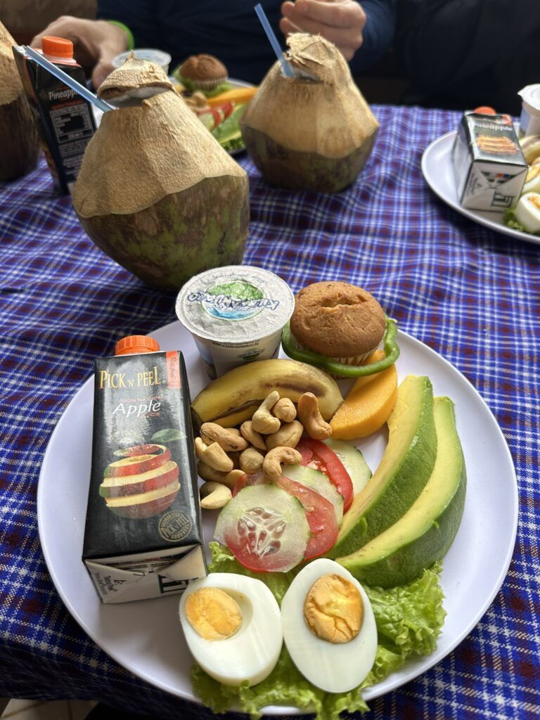 A plate of food with a bottle of apple juice and eggs on a table.