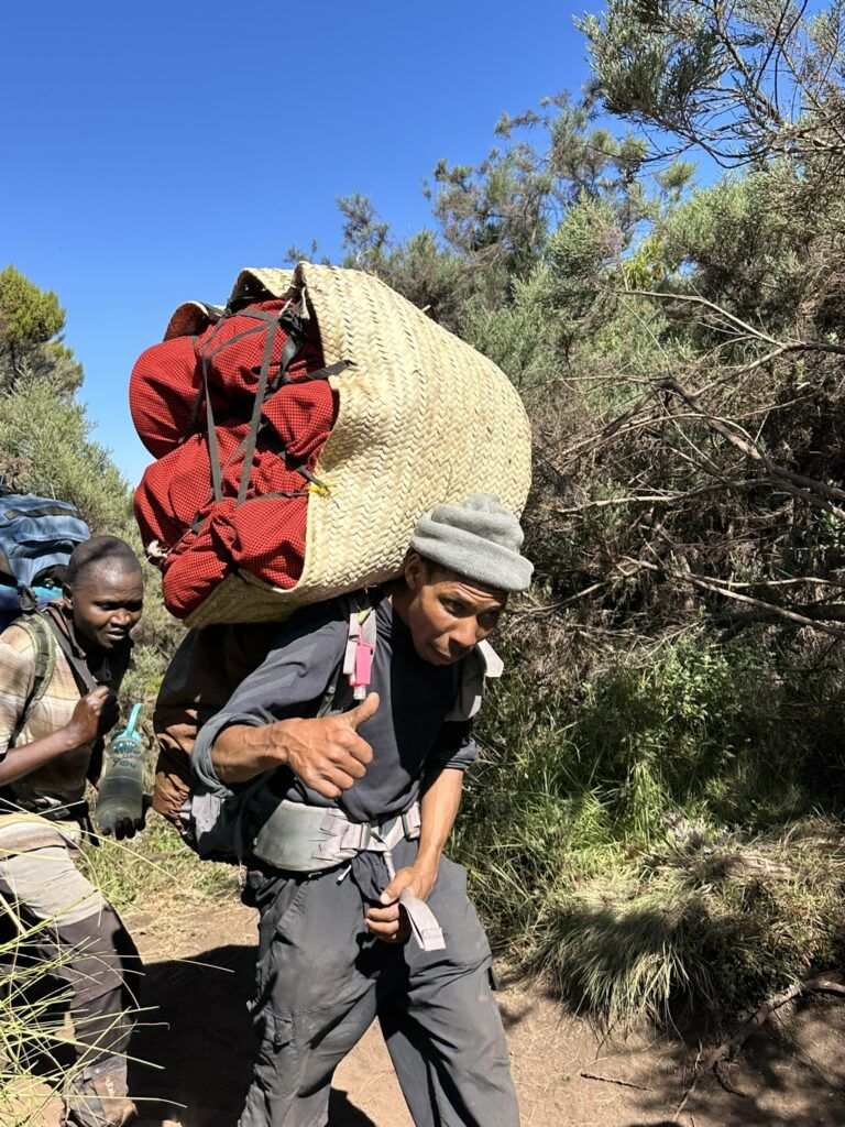 A man is carrying a large basket on his back.