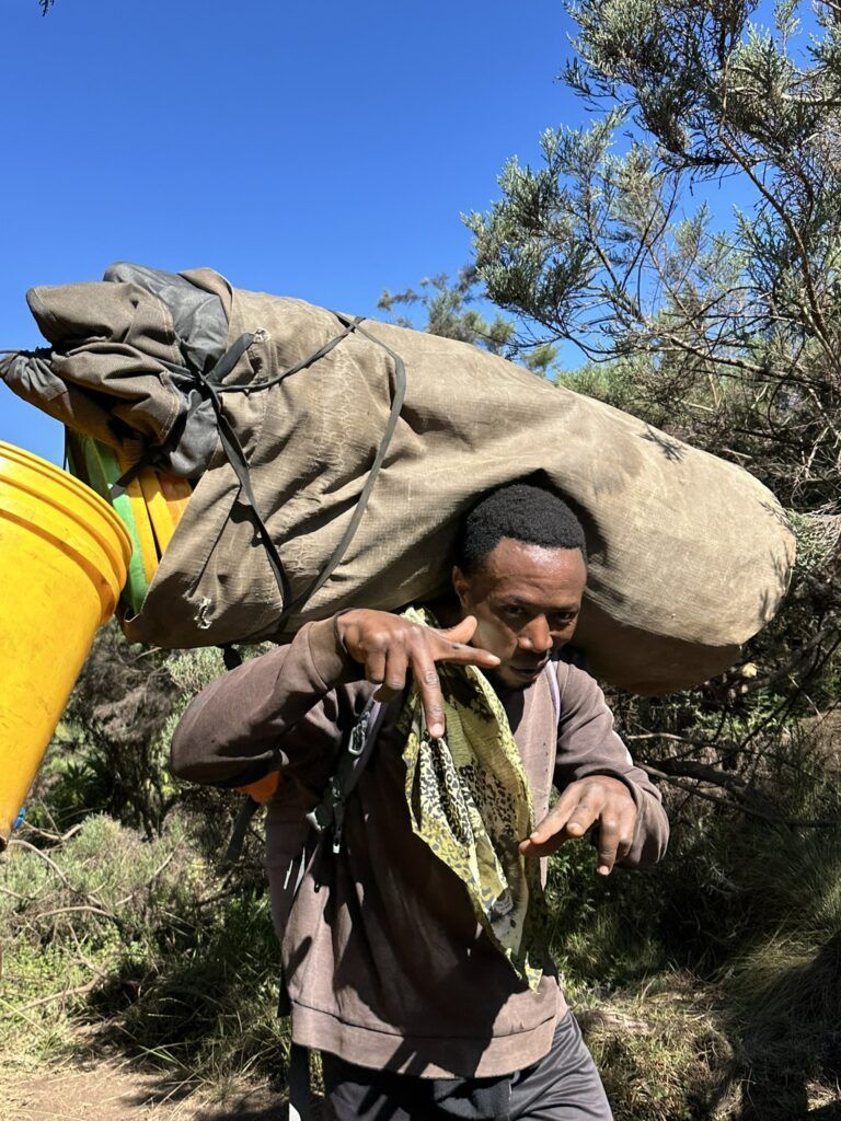 A man is carrying a large bag on his back.
