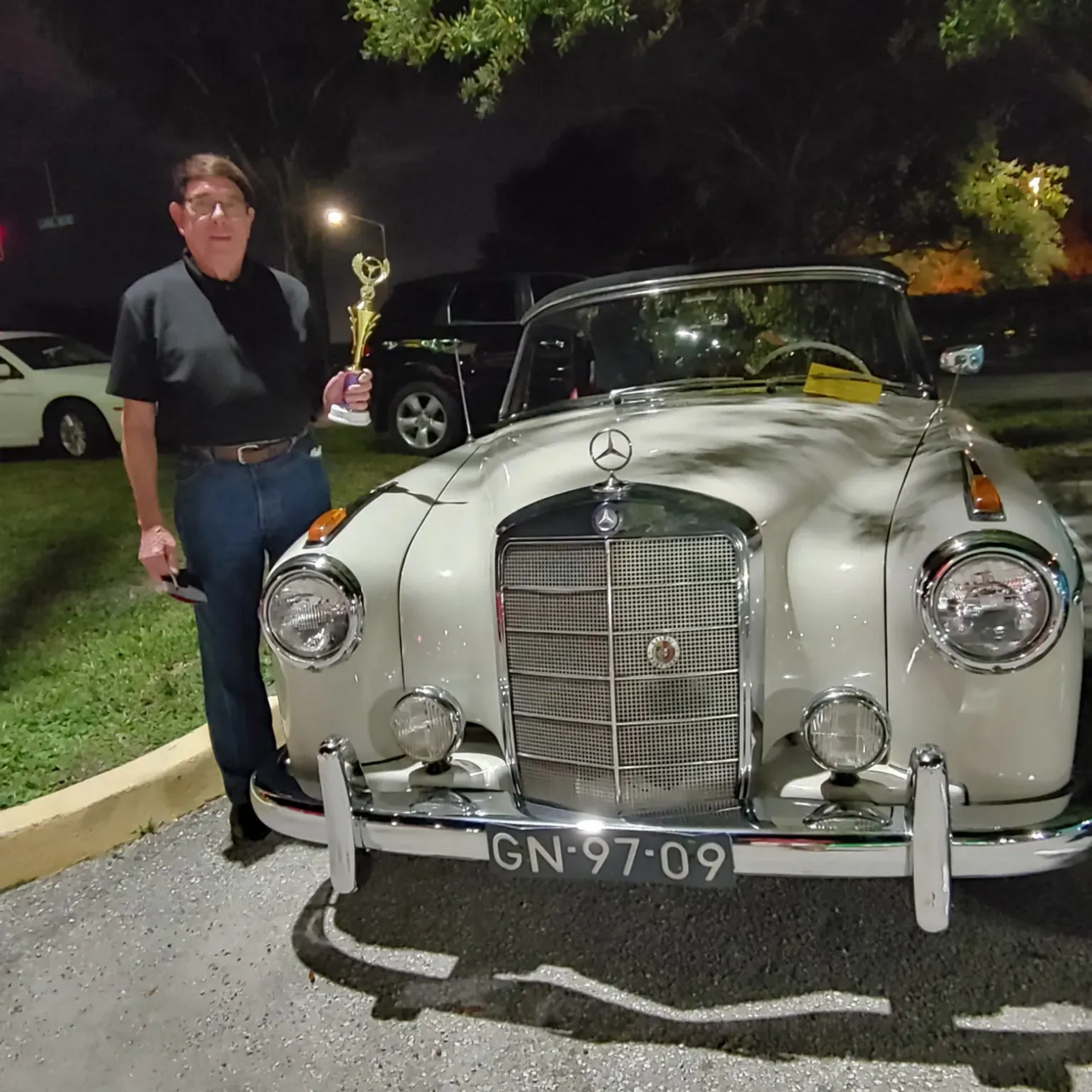 Owner-standing-in-front-of-award-winning-vehicle-with-trophy-after-paint-correction-and-ceramic-coat