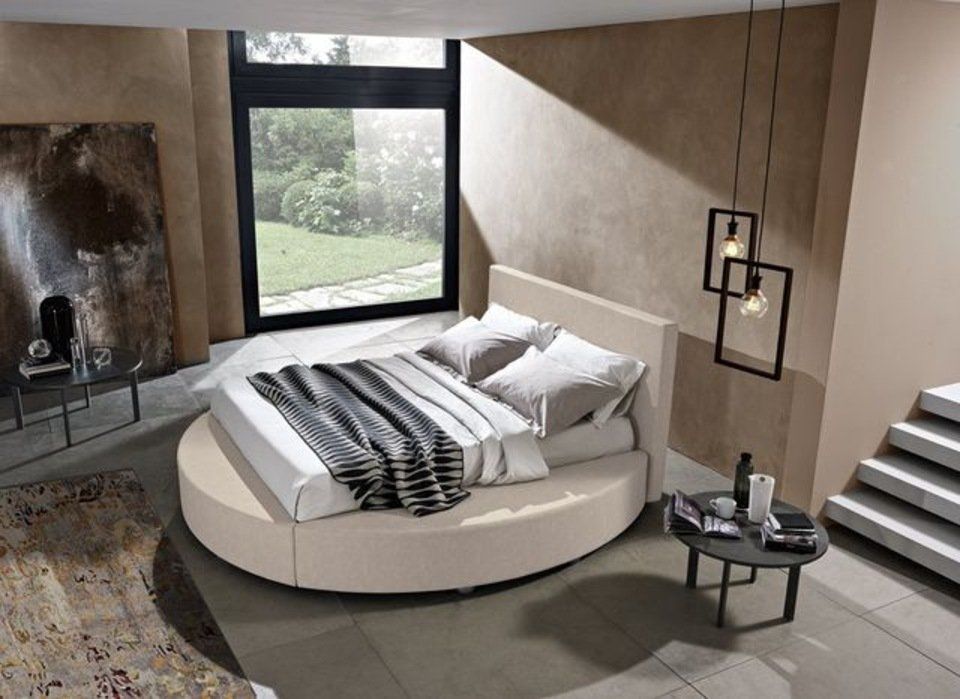 camera con letto ovale e arredi moderni