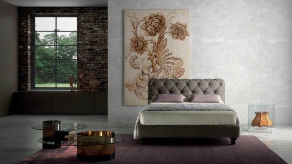 camera con letto matrimoniale imbottito e stampa con fiori