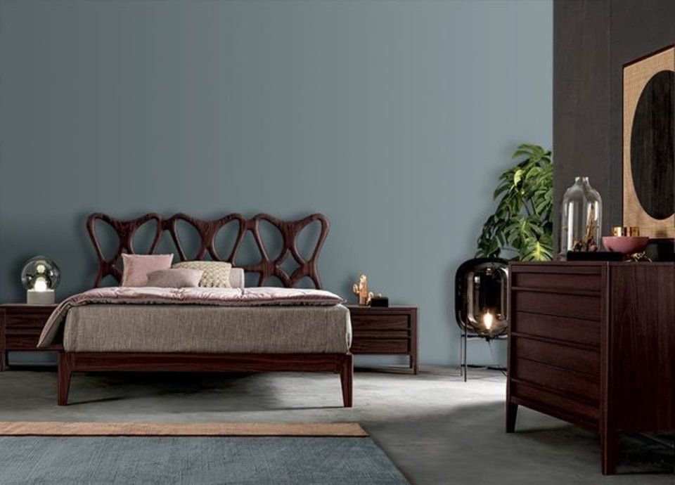 camera con letto e comò in legno scuro