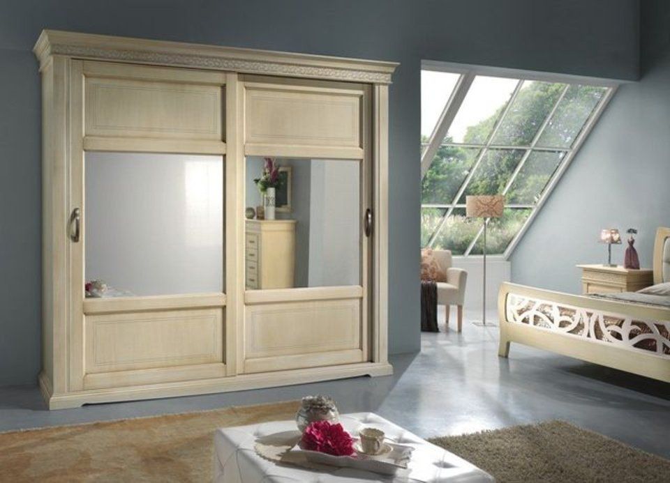 camera con armadio color crema e specchi