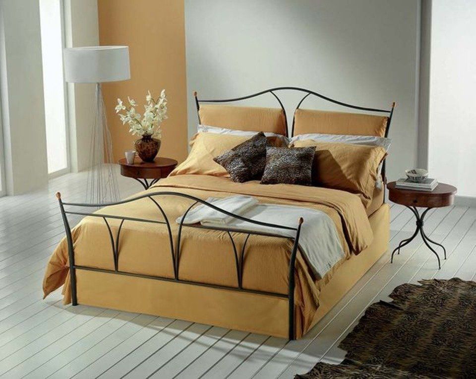 letto con imbottitura gialla e struttura in ferro battuto