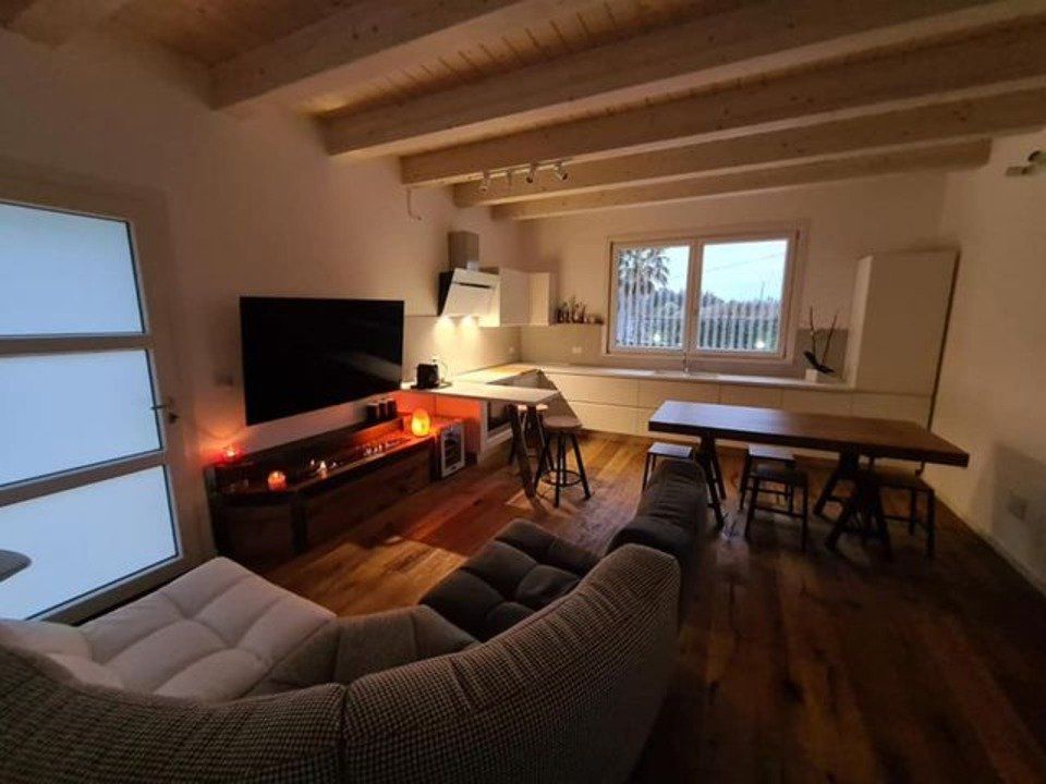 open space con divano angolare e caminetto a gas decorativo