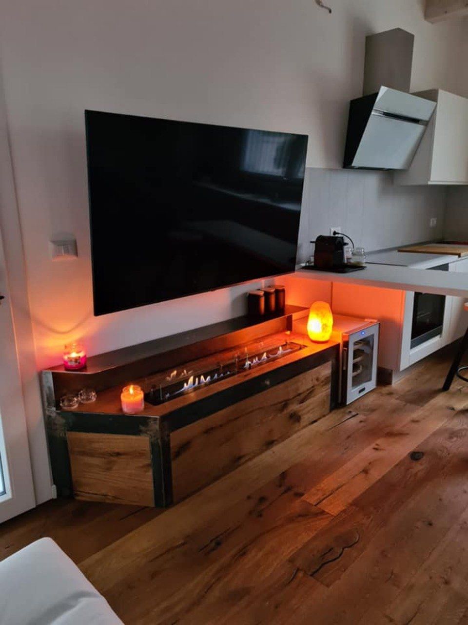 tv appesa, camino decorativo a gas e candele