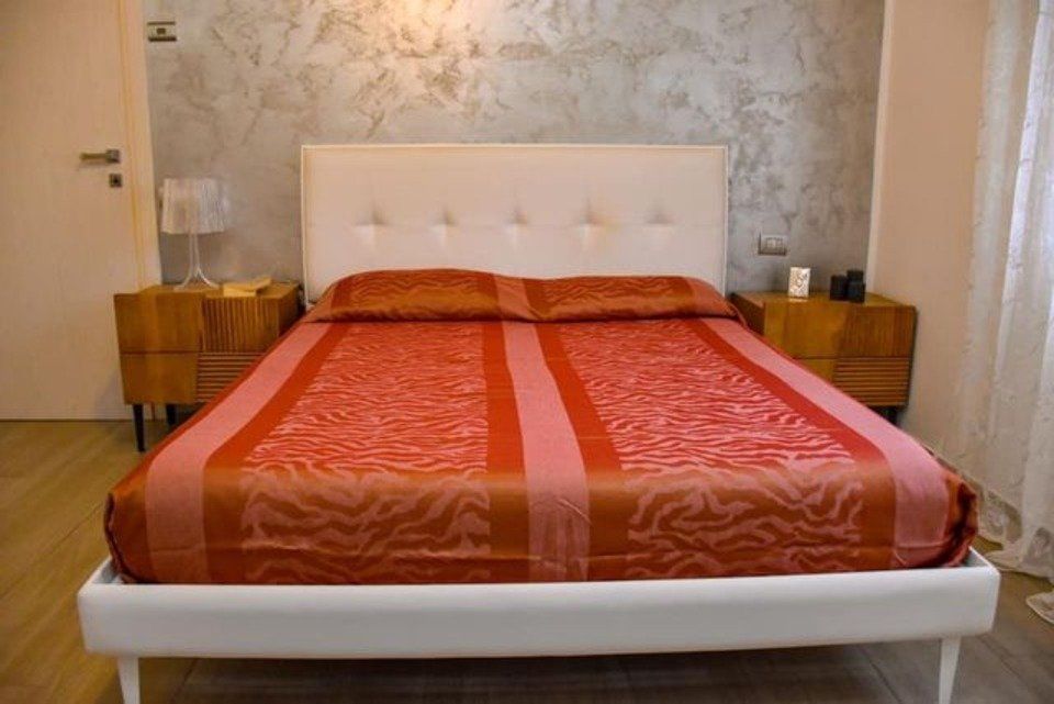 letto trapuntato bianco con lenzuola arancioni e rosse
