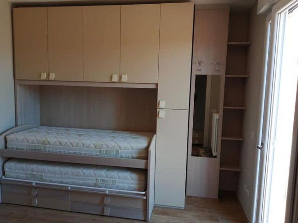 cameretta con 2 letti singoli e armadi beige