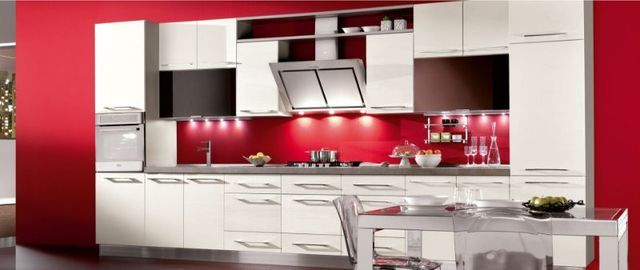 cucina con moduli color panna e parete rossa