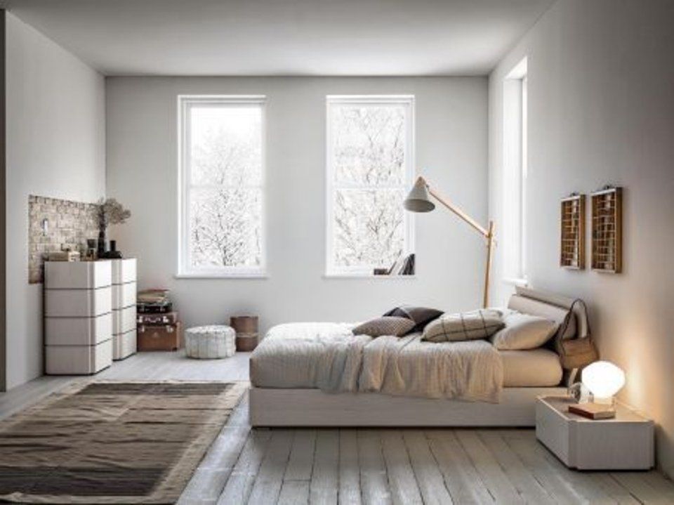 camera da letto con arredi chiari e pavimento in legno