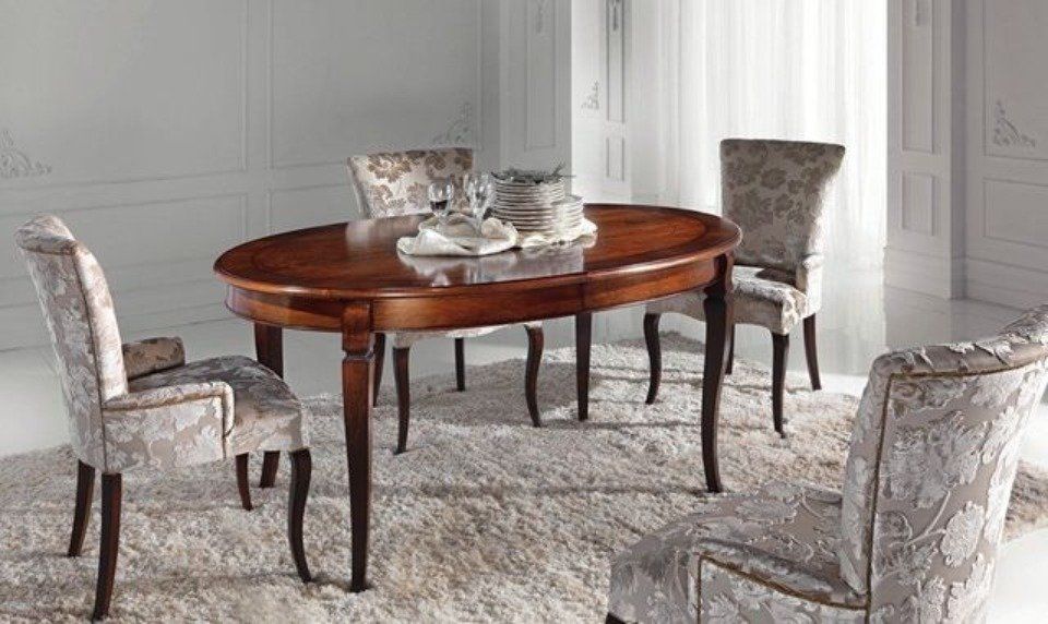 tavolo ovale in legno e sedie in tessuto decorate