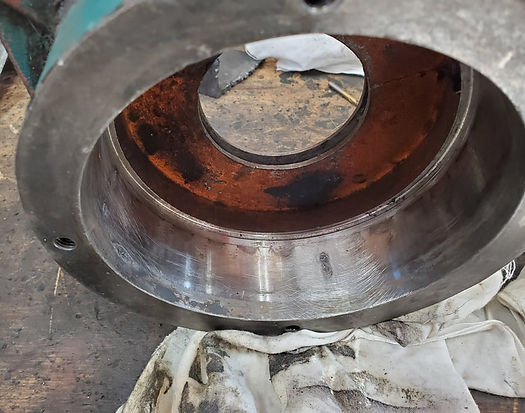 Close-up of a metal cylinder with rust and wear inside. A white cloth sits below.