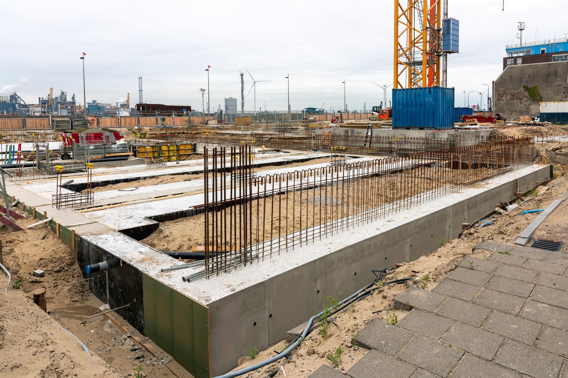 An overview of a construction site where the concrete foundations and reinforcement are being set.